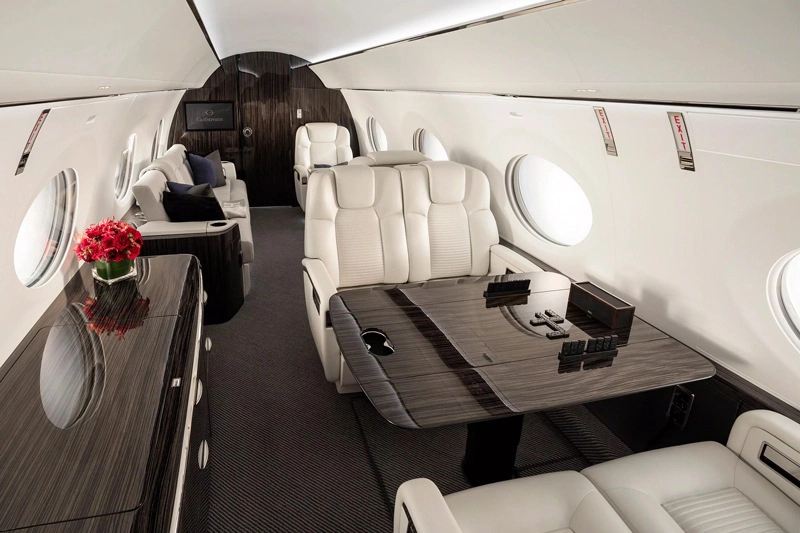 Luxurious white leather seats inside a private jet cabin.
