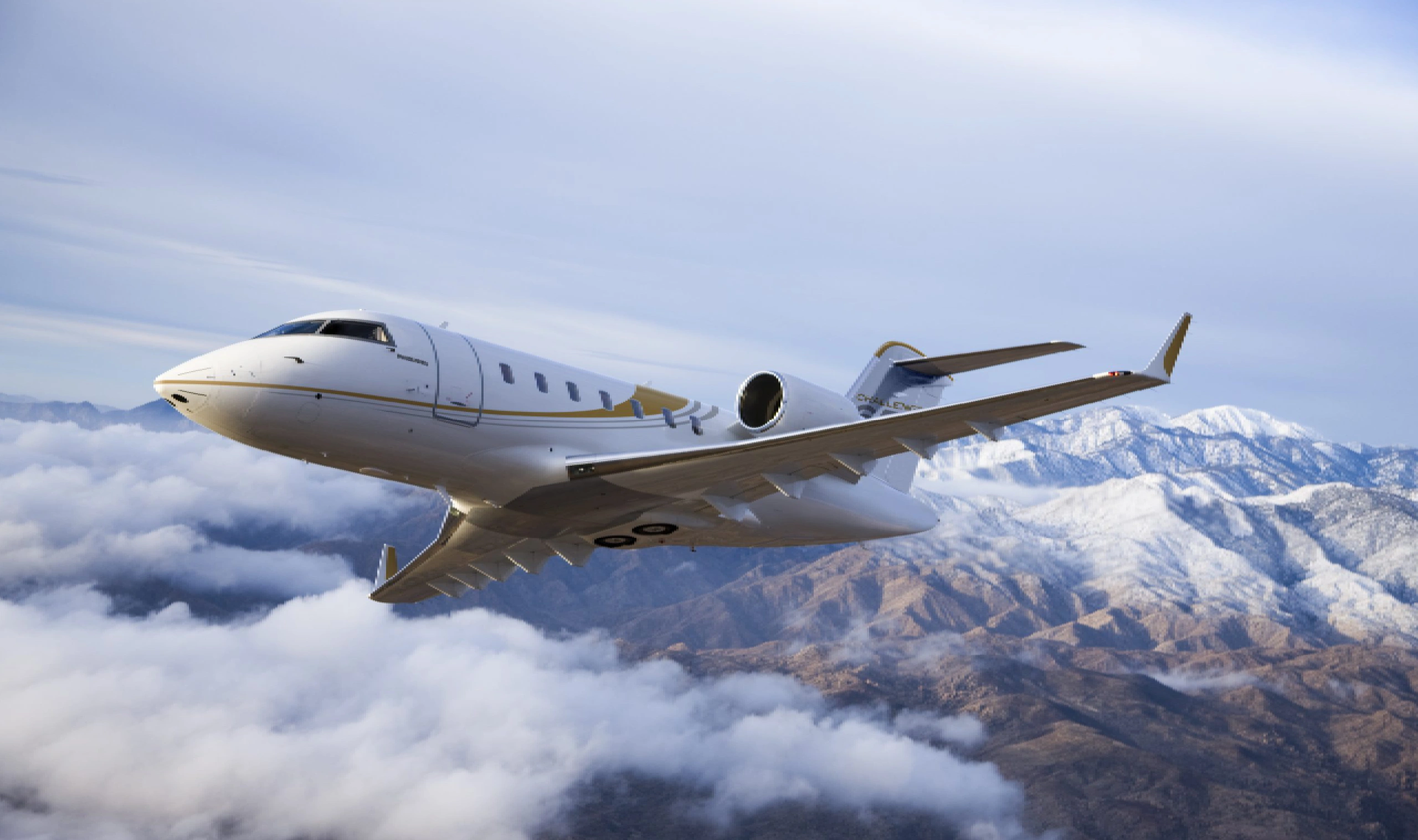 A private jet flying above clouds with snowy mountains in the background.