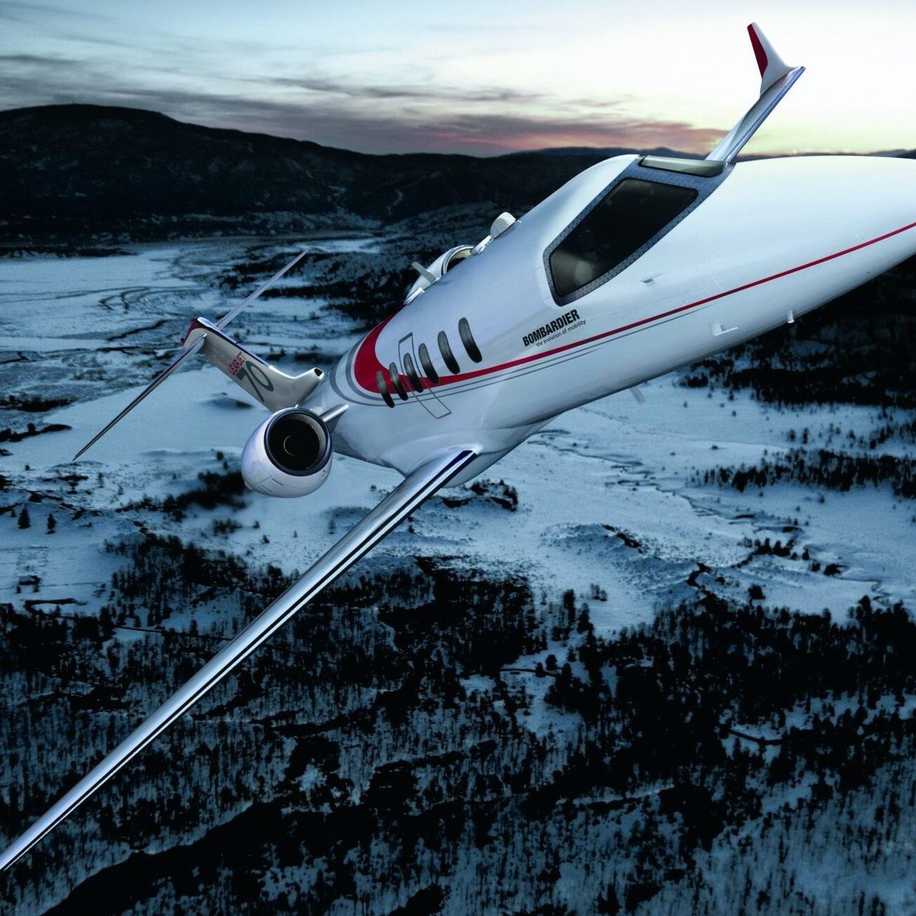 A private jet flying over a snowy mountainous landscape during dawn.