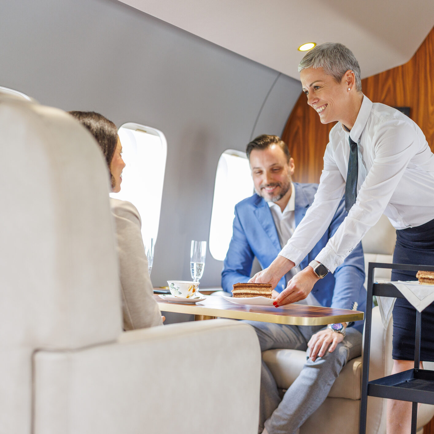 Flight attendant serving passengers on airplane.